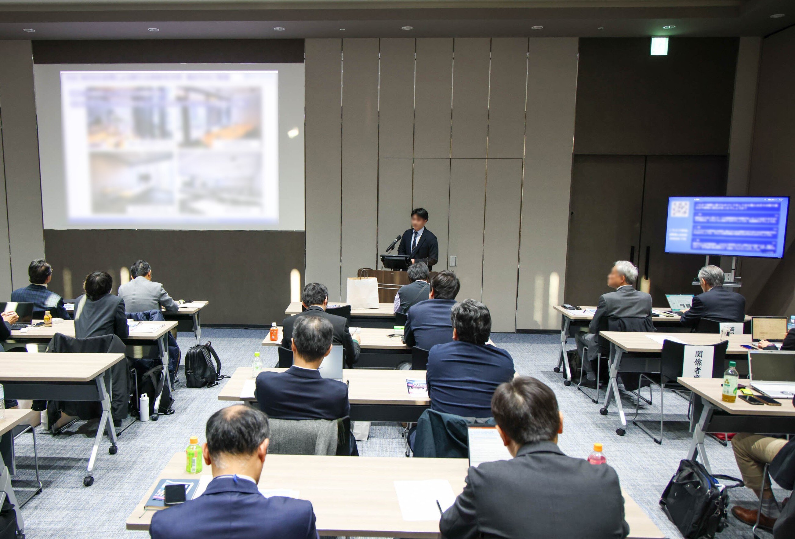 講演資料をスクリーン投影＋参加者のリアルタイム質問をディスプレイ表示したセミナー会場